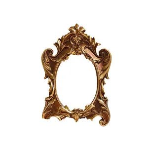 Vintage ornate golden oval photo frame with Baroque style floral carvings on white background