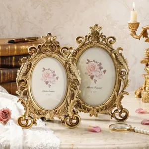 Pair of vintage ornate golden oval photo frames featuring intricate baroque floral carvings