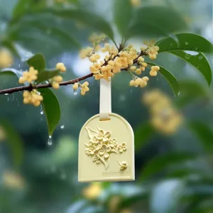 Osmanthus scented plaster tablet car air freshener hanging on a flowering branch