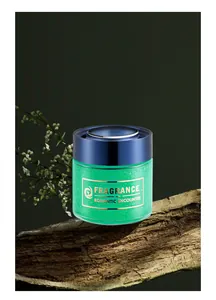 Macro view of premium green car fragrance balm on textured wood with dark background