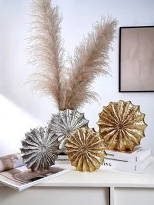 Detailed view of modern resin vases with metallic gold and silver shell textures.