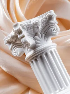 Macro detail of white Roman column ornament with cherub carving on silk background