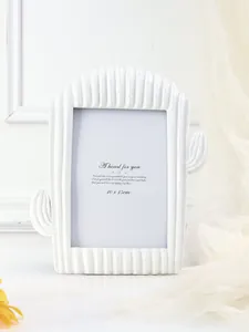Primer plano de un marco de fotos de resina blanca con forma de cactus elegante