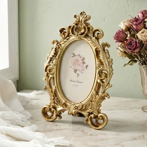 Detailed view of ornate gold vintage oval photo frame with intricate carvings on marble