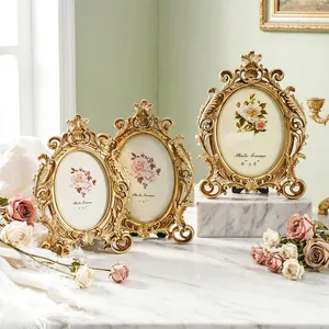 Ornate vintage gold oval photo frames with intricate European style carvings displayed