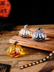 Detail view of three colorful iridescent glass pumpkins on rustic wood for Halloween.
