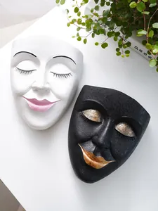 Close-up of black and white resin face planters with textured finish and metallic lips.