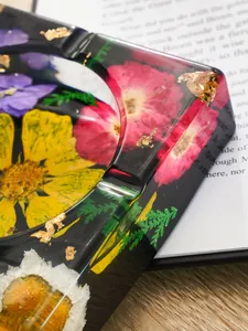 Detalle en primer plano de cenicero de resina con flores secas y pan de oro