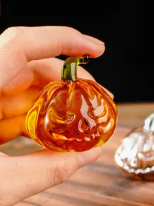Detailed view of hand-held amber glass pumpkin with jack-o'-lantern face