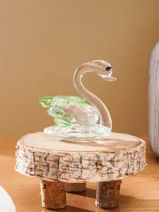 Detailed view of an elegant crystal swan figurine on a rustic wooden stand