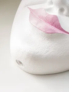 Close-up macro detail of minimalist white resin face planter with textured pink lips