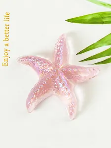 Primer plano de una estrella de mar de cristal rosa iridiscente con hojas verdes
