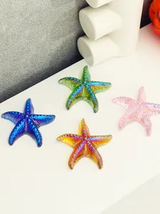 Vista detallada de decoraciones de estrellas de mar coloridas en un estante blanco.