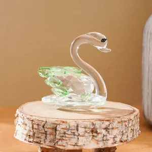 Elegant crystal swan figurine with green wings on wooden pedestal for home decor