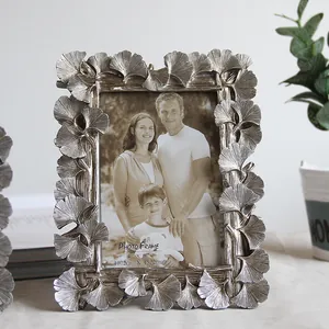 Intricate detail of antique silver resin photo frame with ginkgo leaf pattern engraving
