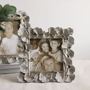 Detail view of an ornate silver ginkgo leaf resin photo frame with textured finish
