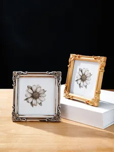 Detailaufnahme von verzierten Fotorahmen im europäischen Reliefstil mit Blumeneinsätzen