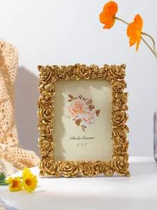 Close-up detail of ornate golden rose-carved picture frame in elegant vintage European style