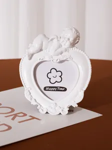 Detailed view of a white heart-shaped resin photo frame with a sleeping angel ornament.