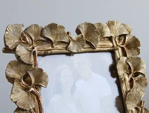 Close-up detail of golden ginkgo leaf patterns on a decorative resin photo frame.