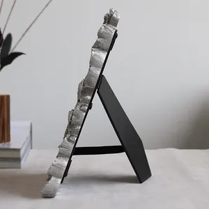 Side view of creative silver resin photo frame with ginkgo leaf texture and stand