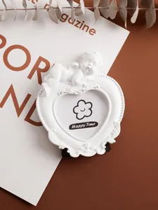 Detailed macro view of a white heart-shaped resin photo frame with sleeping angel decor