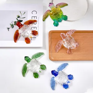 Artistic detail of five colorful transparent glass sea turtle figurines arranged on a white surface