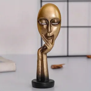 Detailed view of the golden abstract mask figurine Silence is Golden for home desk decor