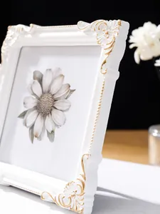 Detailansicht eines kunstvollen weißen Fotorahmens im europäischen Stil mit Goldrelief.