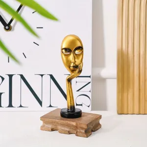 Detailed macro view of golden abstract mask sculpture with wooden base