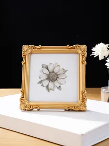 Detailaufnahme eines goldenen Fotorahmens mit eleganten floralen Prägungen im Vintage-Stil