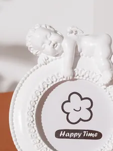 Detailed close-up of white resin angel photo frame featuring vintage European carving