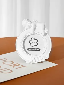 Detailed close-up of a white vintage resin angel photo frame with cherub ornament