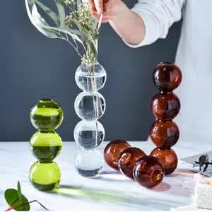 Elegante moderne blasenförmige Buntglasvasen in Grün Transparent und Bernstein auf Marmor