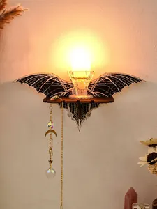 Macro detail of bat wall shelf featuring crystal candle holder and hanging moon charm