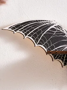 Close-up detail of gothic bat wing wall shelf featuring white spiderweb vein patterns