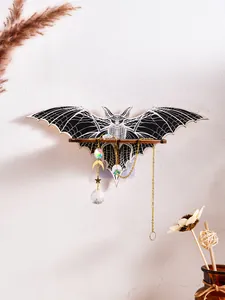 Detailed view of a bat-shaped wooden wall shelf featuring hanging crystal suncatchers