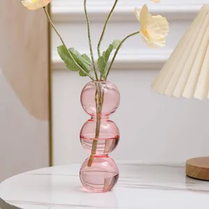 Nahaufnahme einer kreativen rosa Glasvase mit drei übereinander gestapelten Kugeln