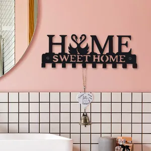 Decorative black iron wall-mounted hook rack featuring swans and Home Sweet Home cutout design.