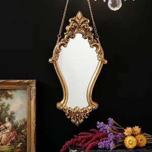 Detail of an ornate gold carved wall mirror featuring vintage European baroque relief design