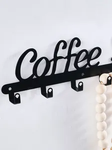 Close-up of decorative black metal coffee sign wall hooks for key and mug storage