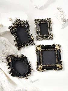 Detailed view of four assorted European mini vintage black and gold magnetic photo frames