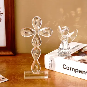Gros plan de figurines en cristal en forme de croix et d'ange sur un bureau