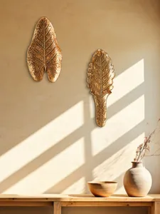 Détail de décorations murales en résine dorée en forme de feuilles dans une pièce ensoleillée
