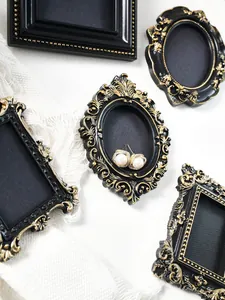 Detailed view of retro mini black and gold magnet frames featuring pearl earrings display