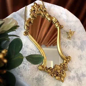 Close-up of ornate gold vintage mirror with intricate baroque relief carvings