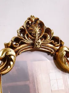 Dettaglio di una cornice per foto vintage in resina dorata decorata con intagli a corona