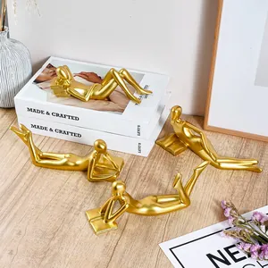 Detailed view of four golden abstract reading figurines arranged on a wooden desktop
