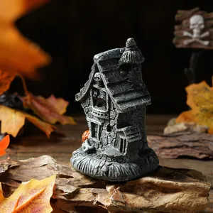 Detailansicht eines grauen Halloween-Geisterhauses aus Harz mit Totenkopf-Dekor.