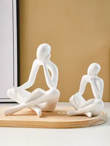 Two white minimalist thinker reading figurines on a wooden tray for modern home decor